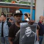 Een demonstrant toont een portret van Mitch Henriquez - foto: Pieter Hofmann.
