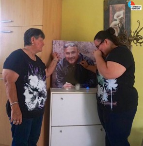 Moeder Maria en zus Jermaine bij een uitvergrote foto van Mitch - foto: Sharina Henriquez
